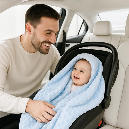 bébé enveloppé dans sa couverture bébé installé sur son siège auto