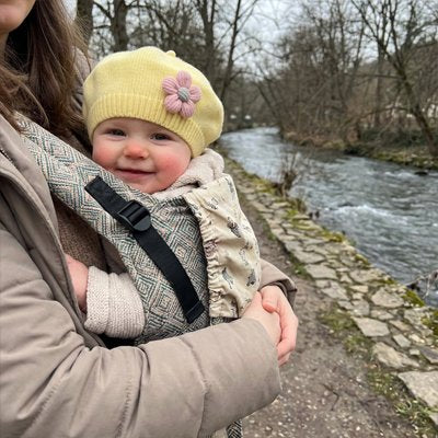 Bonnet bébé avec une applique en forme de fleur cousue sur le côté